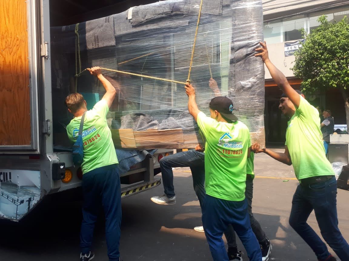 Equipo subiendo un mueble protegido al camión