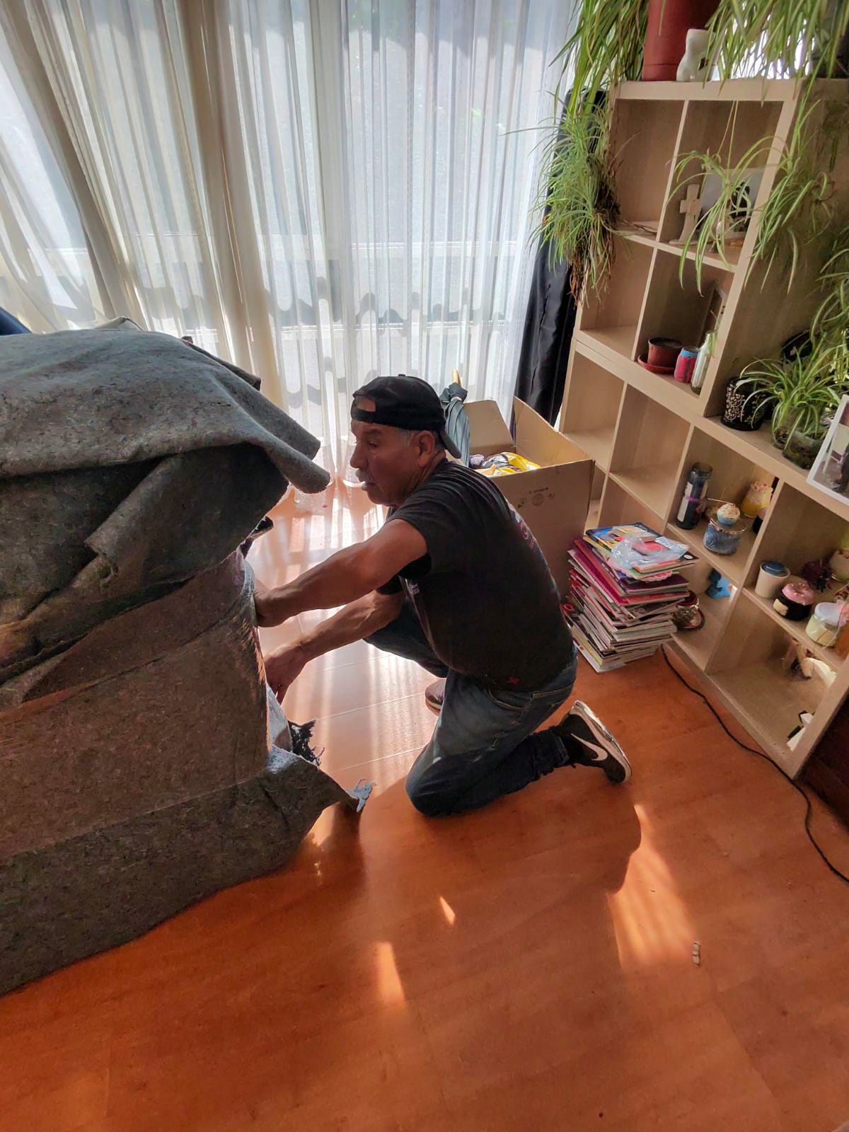 Trabajador protegiendo un mueble antes de cargarlo