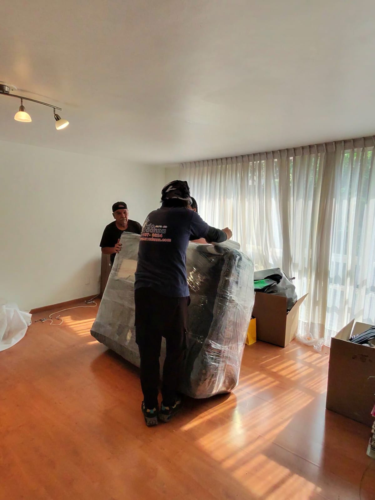 Personal de Todo para su Mudanza moviendo un mueble protegido